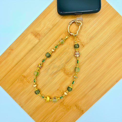 Close-up of a green glass bead phone charm for Lunar New Year connected using a phone tab connector.